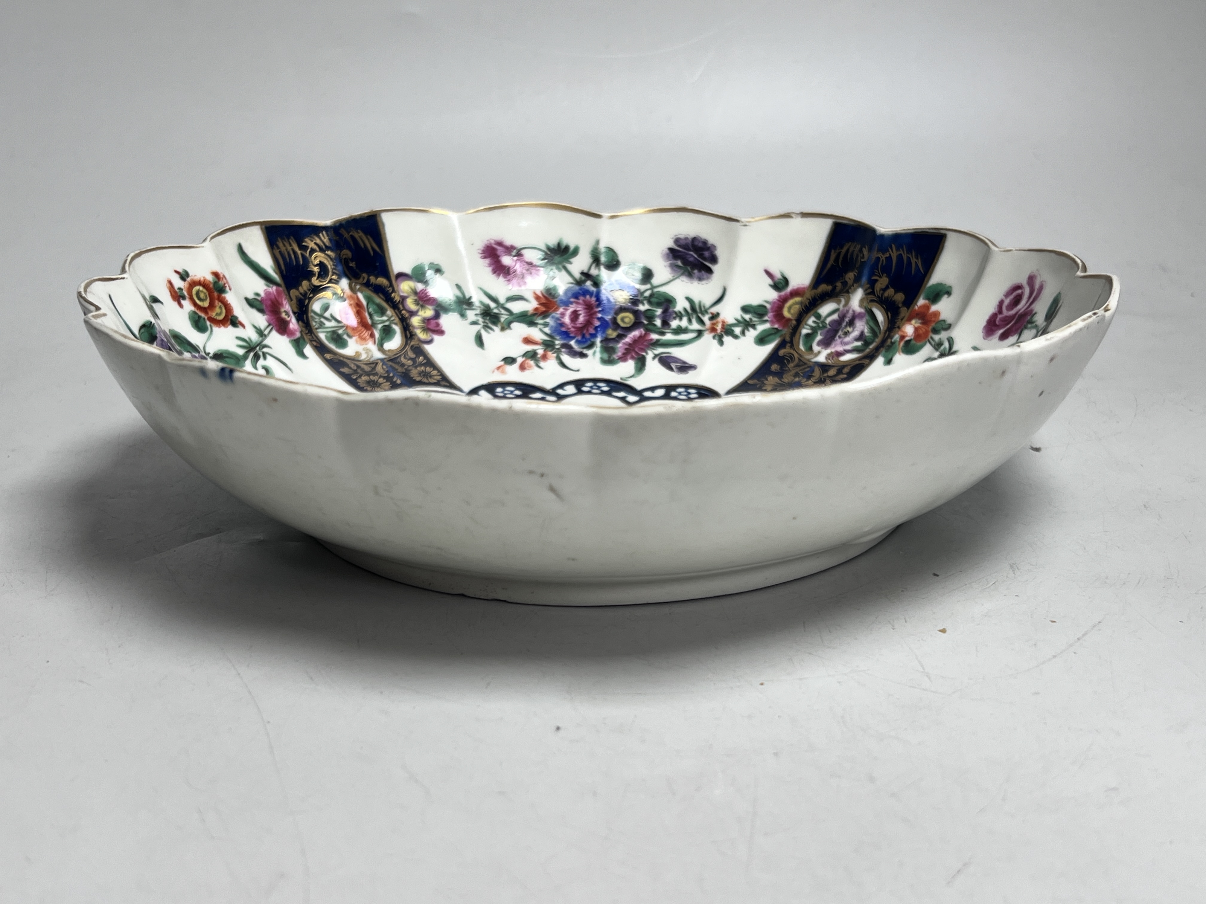 A Worcester fluted dish painted with butterflies and flowers in the manner of James Giles, seal mark, c.1770, 26cm diameter